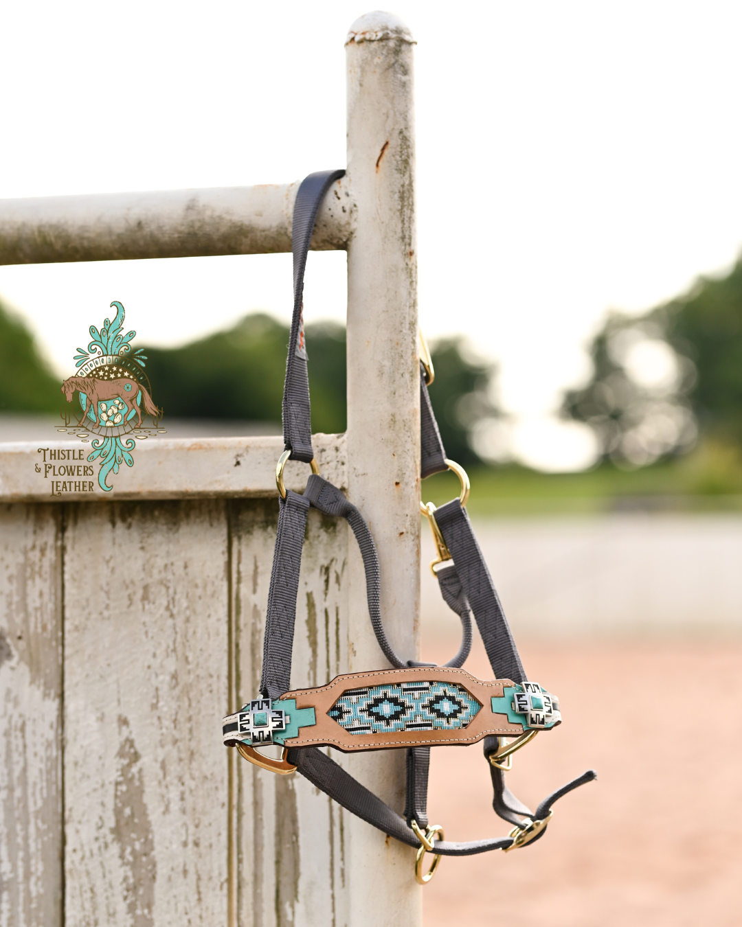 Grey horse halter a tooled and painted noseband. Noseband has a beaded inlay. Beaded inlay is an Aztec-inspired design, with blue, turquoise, black, white, and gold beads. Leather part of noseband also has an Aztec-inspired design, with turquoise, white, and black elements. Conchos are a western cross with a faux turquoise stone in the center. 