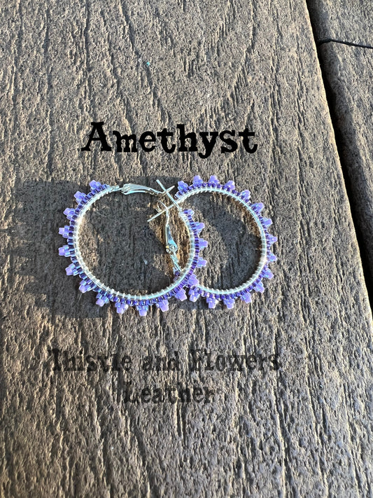 Mini hoop beaded earrings. Silver colored earring base, with a darker purple base beaded , with a light purple tip on the triangular extension on the earrings.  